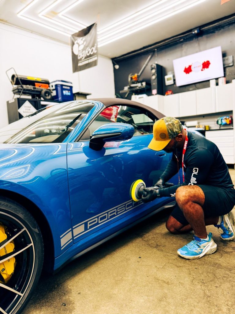 Joseph Stein performing paint correction while polishing a Porsche during professional detailing service